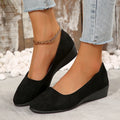 Women's black suede low wedge pumps with pointed toe and shallow mouth design on a rubber sole.