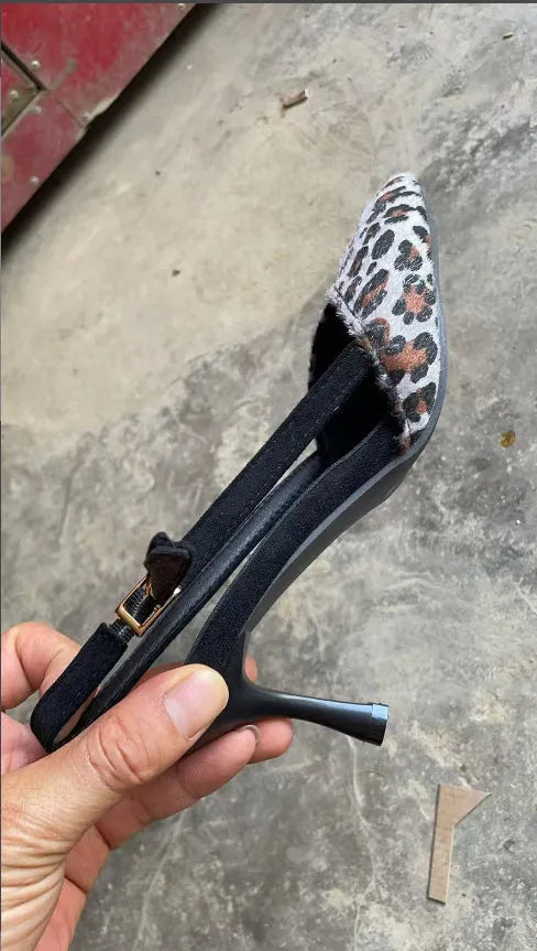 Leopard print suede women's sandals with a pointed toe on a foot mannequin.