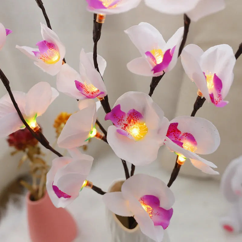 Pink Phalaenopsis orchid branch shaped LED decorative light on a table.