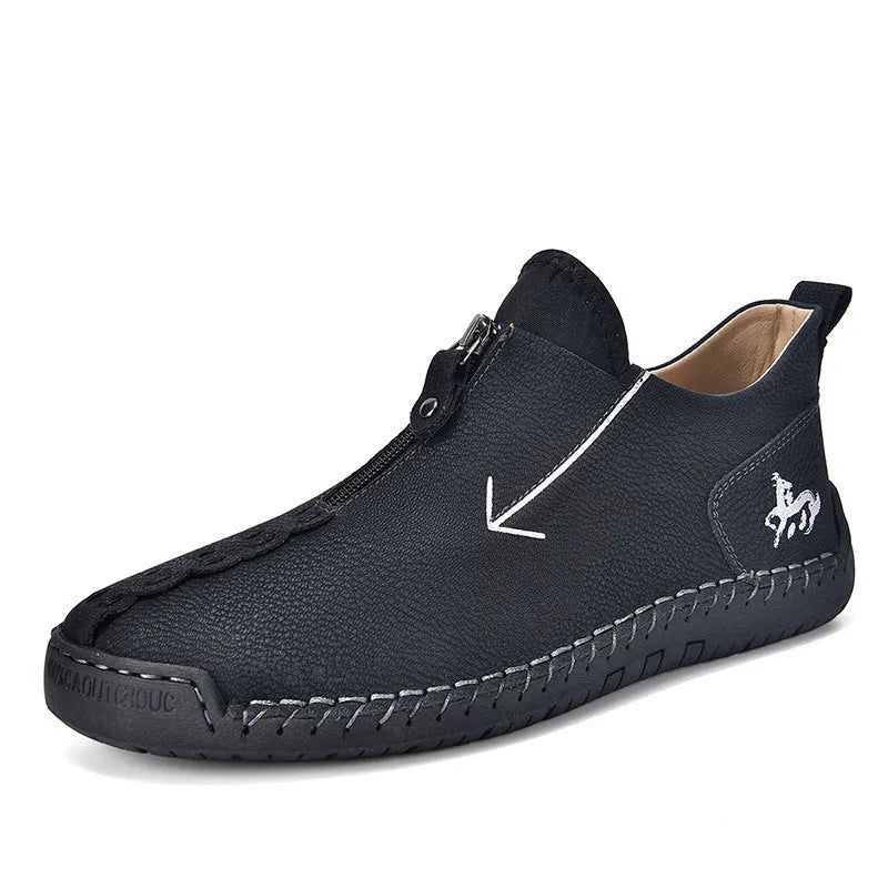 Men's black leather boots with a front zipper and round toe, showing hand-stitched sole detail.