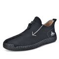 Men's black leather boots with a front zipper and round toe, showing hand-stitched sole detail.