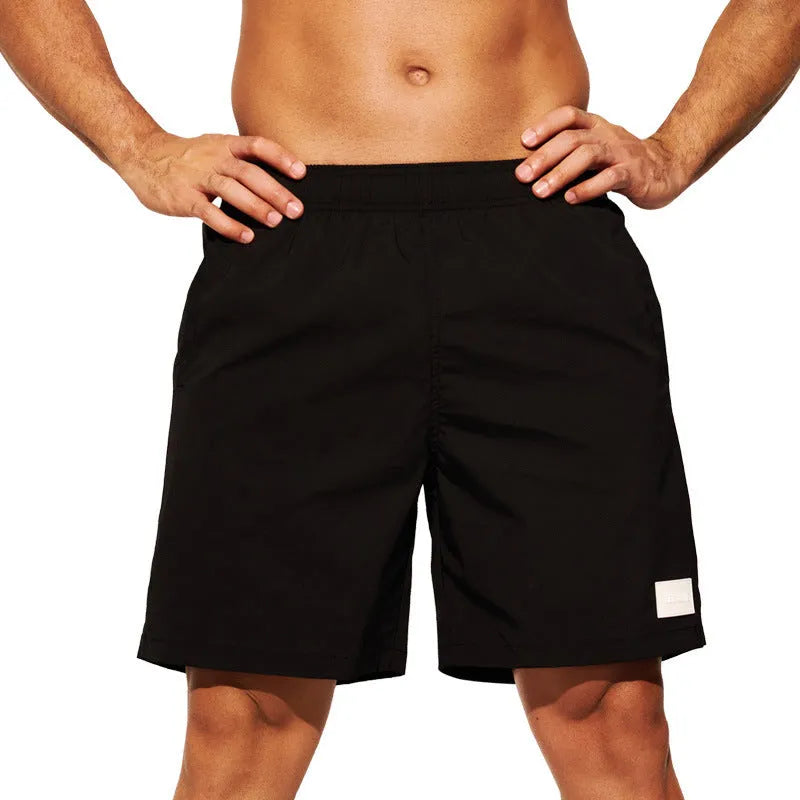 Men's solid colour quick-dry nylon sports shorts on a beach background