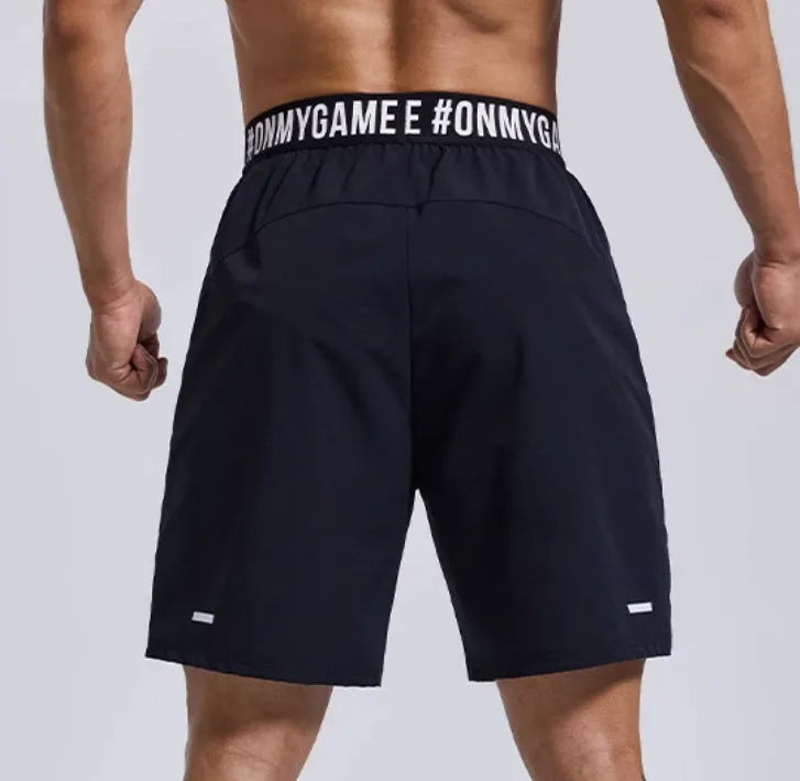 Men's grey workout shorts with loose cropped fit and letters detailing on elastic waist