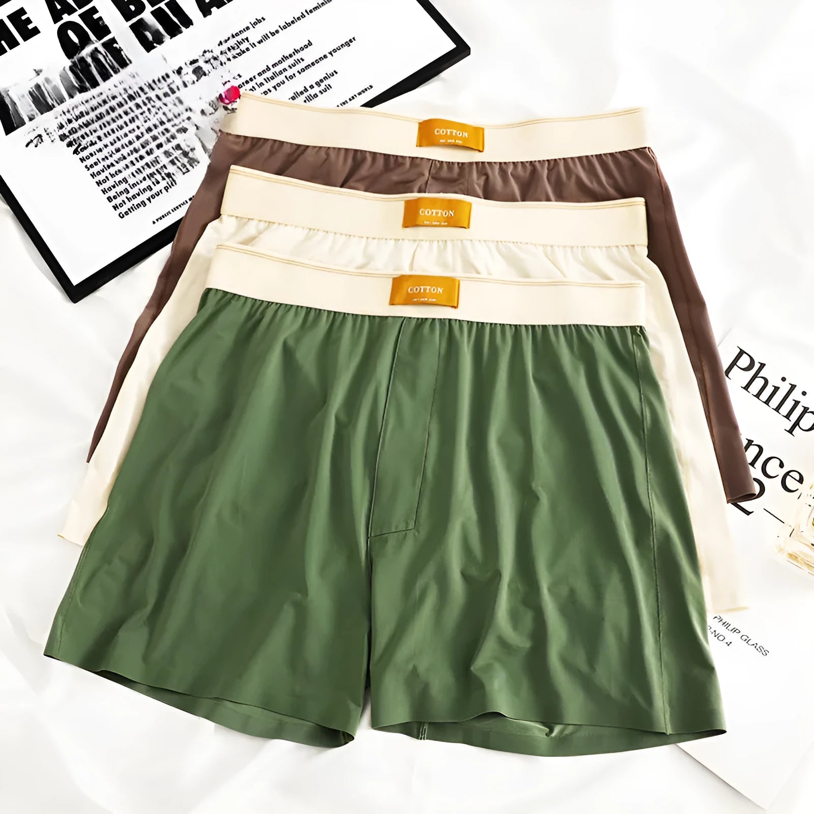 Pack of three pairs of men's solid colour ice silk underwear on a white background.
