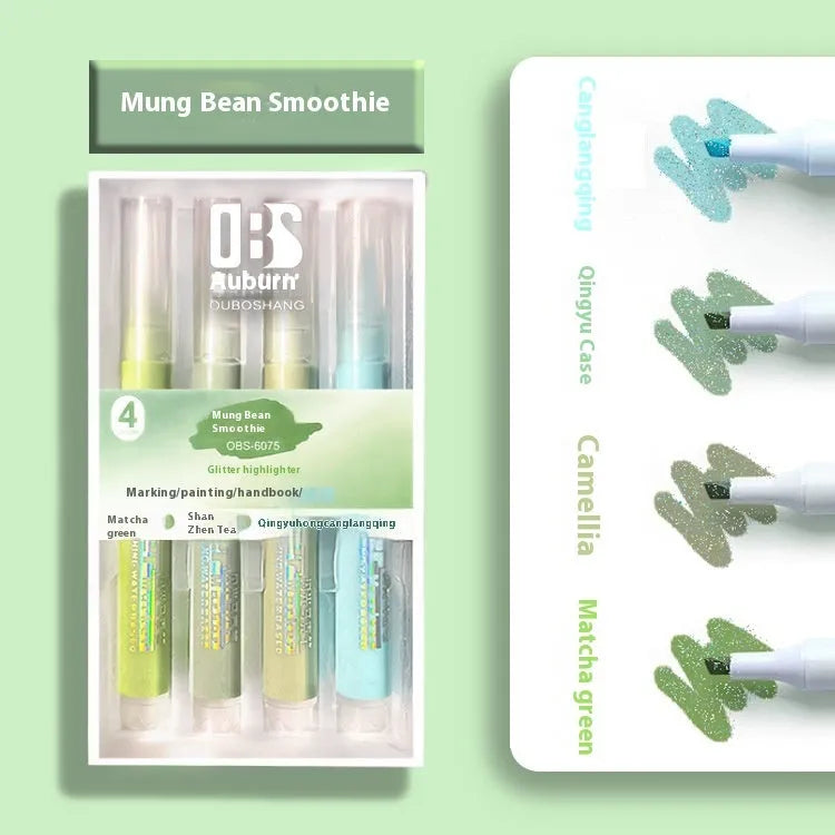 Four glitter highlighter pens with pastel colours and slanted tips on a notebook.