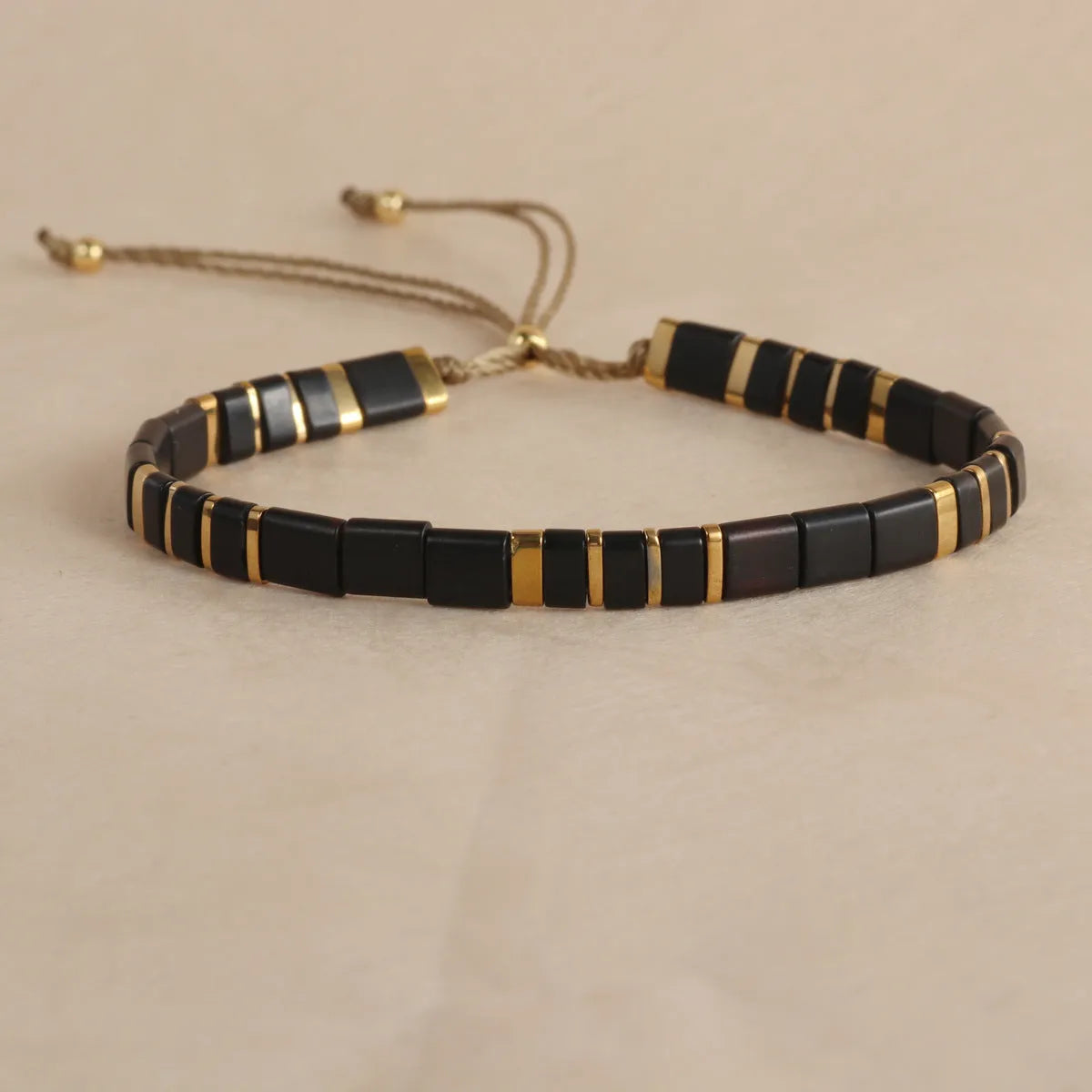 Adjustable pull beads bracelet with glass and coloured glaze beads in geometric and round shapes