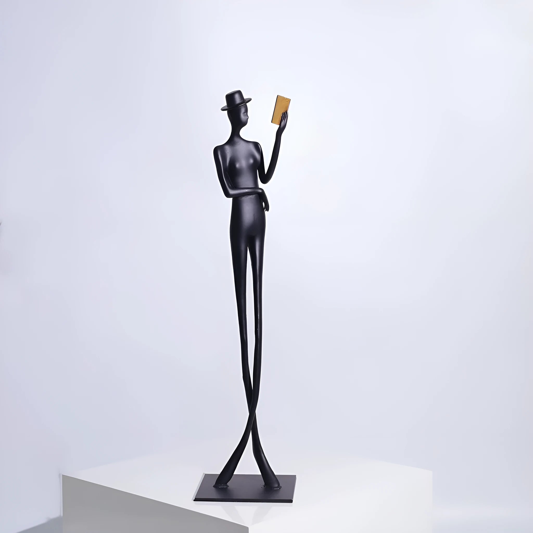 Black aluminium desktop sculpture of a woman reading, modern design.