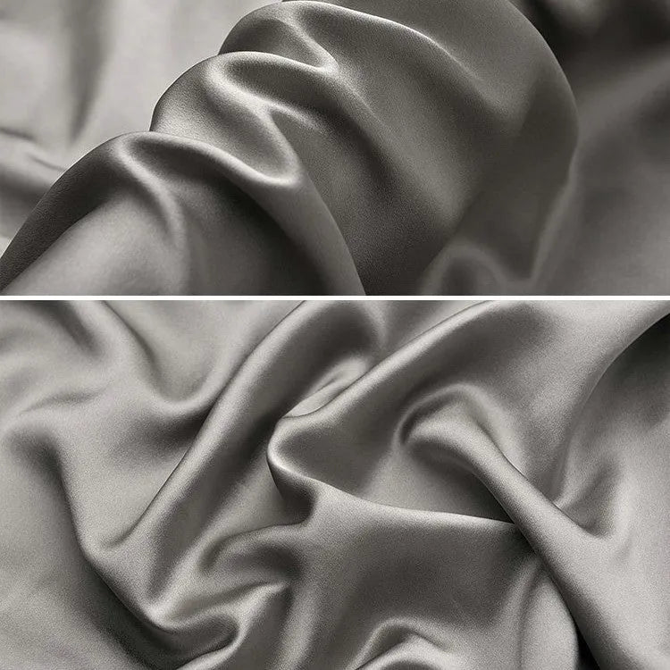 Dark grey silk pillowcase with envelope closure on a bed