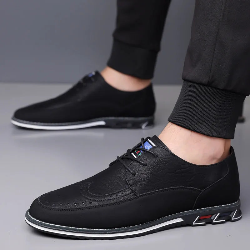 Men's black casual leather slip-on shoes with a rubber sole and visible sewing line details on a leather toe cap.