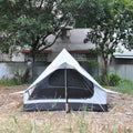 Brown or white A-line hiking tent without poles, supported by hiking canes