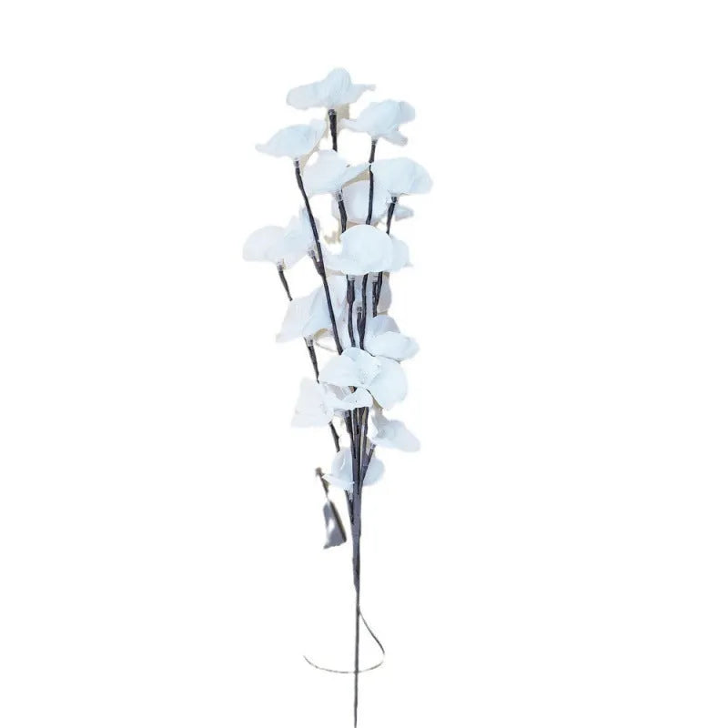 Pink Phalaenopsis orchid branch shaped LED decorative light on a table.