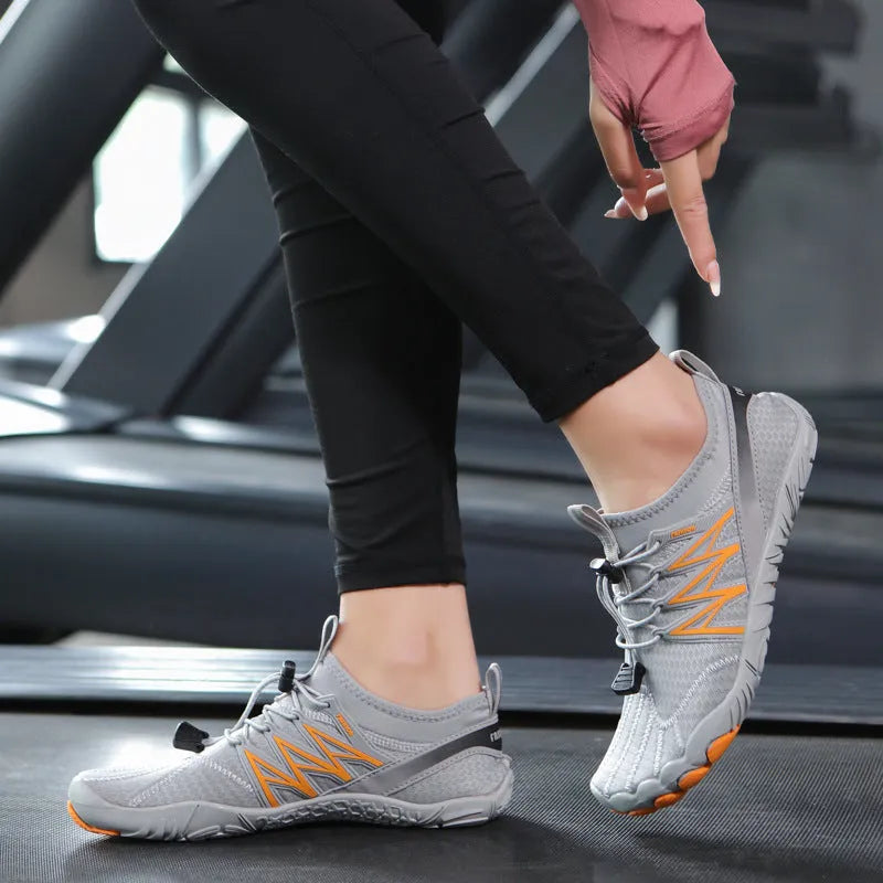 Low-top striped training sneakers with a flat rubber sole, shown in various colours including black and grey orange.