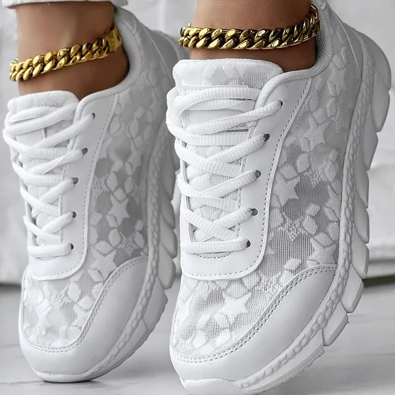 Women's white canvas running shoe with flat heel and round toe on a neutral background.