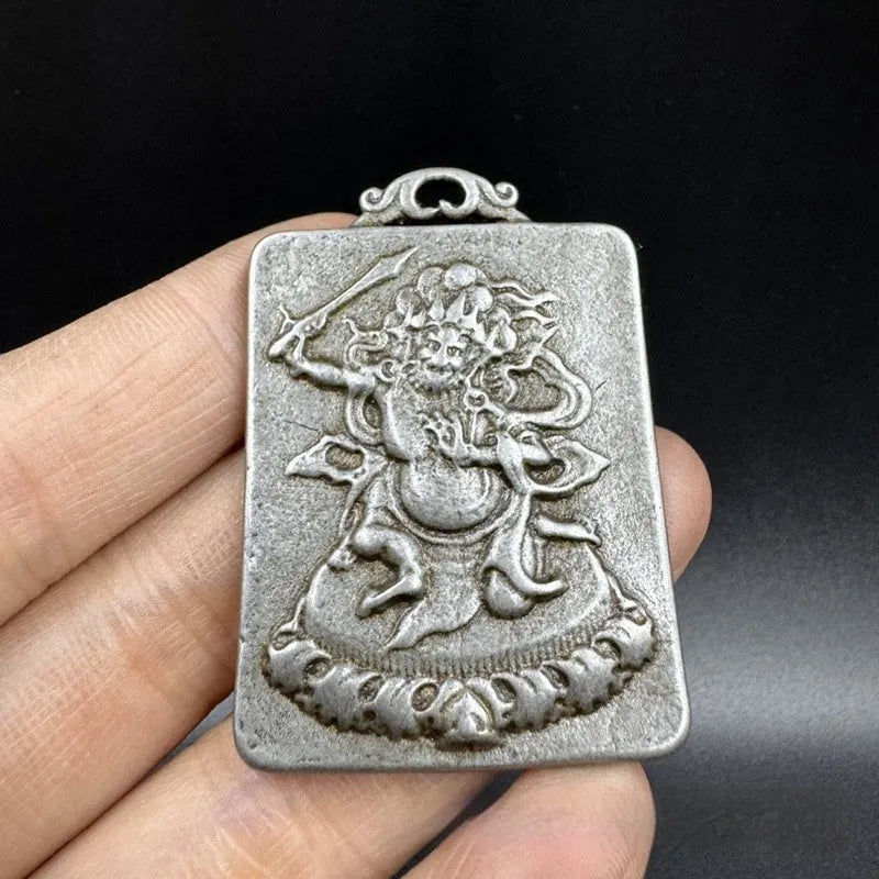 Close-up of a geometric iron pendant ornament in a Chinese style depicting the Aryaacalanatha Yamantaka motif.