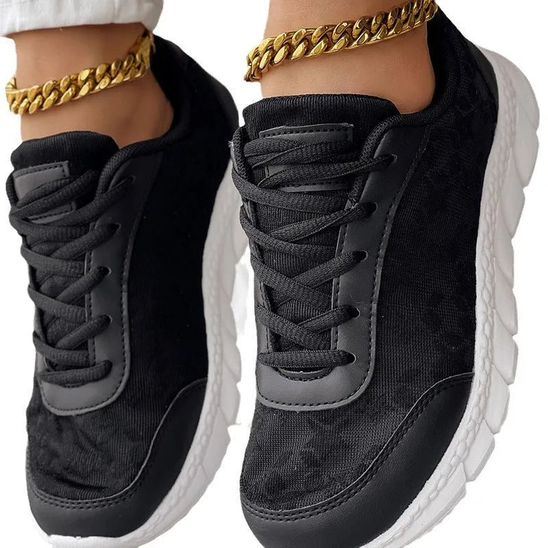 Women's white canvas running shoe with flat heel and round toe on a neutral background.