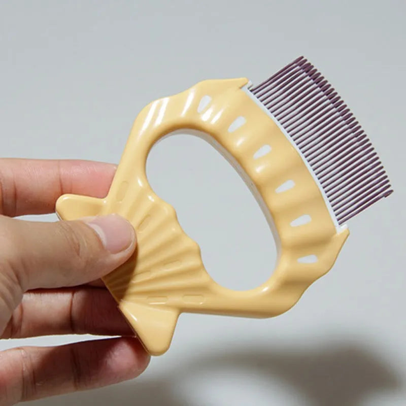 Green shell shaped plastic pet grooming comb with fine bent wire bristles on a white background.