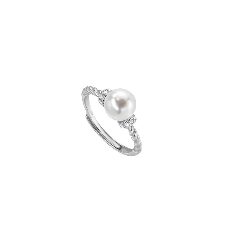 Adjustable geometric twist copper ring with a central pearl, shown in gold and silver colour options.