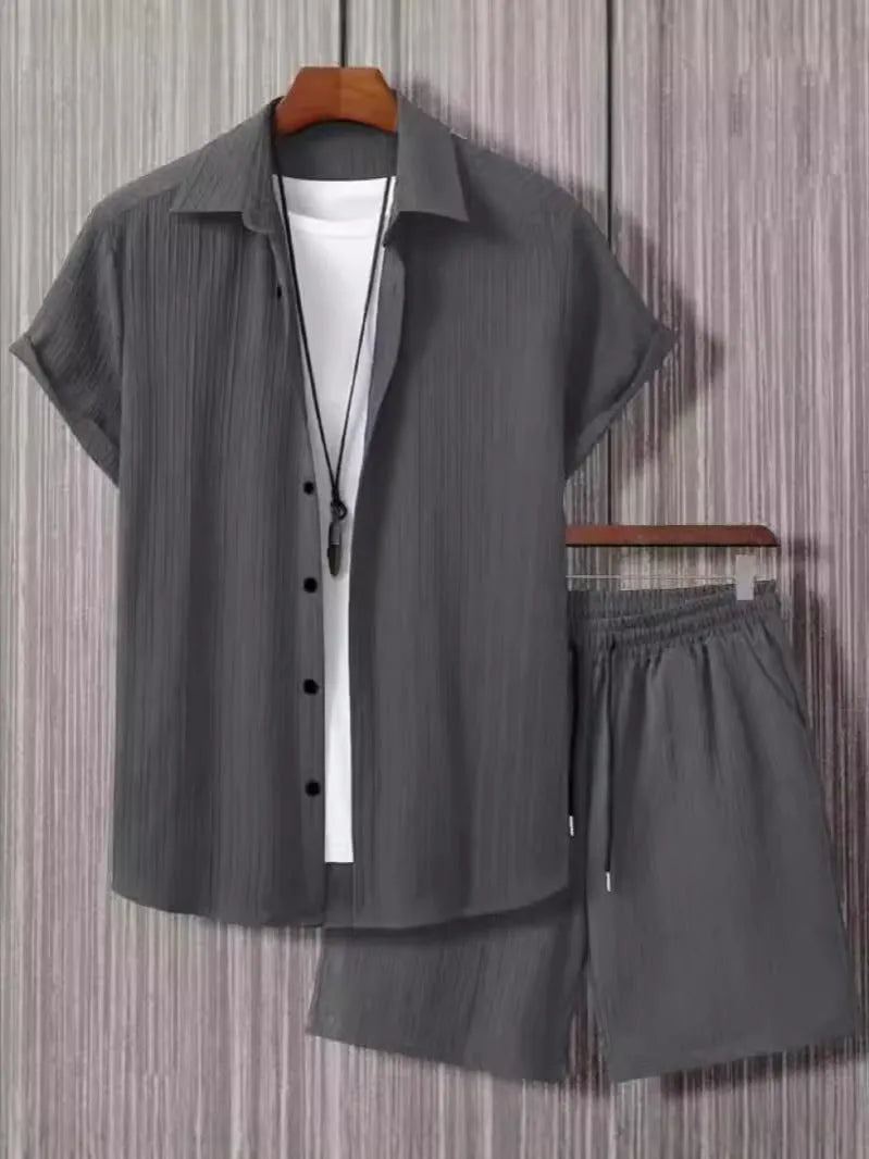 Man wearing a jacquard black short sleeve suit shirt with matching shorts from a two-piece set.