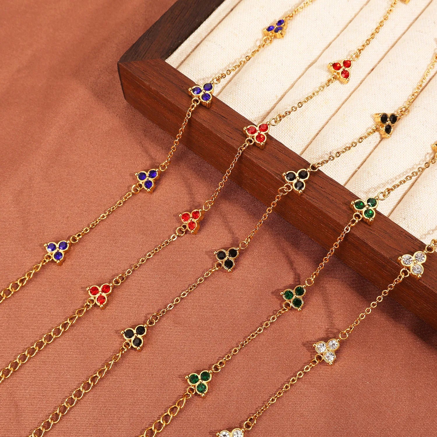 Women's stainless steel bracelet with a geometric triangle pendant, shown in gold and steel tone options with coloured stones.