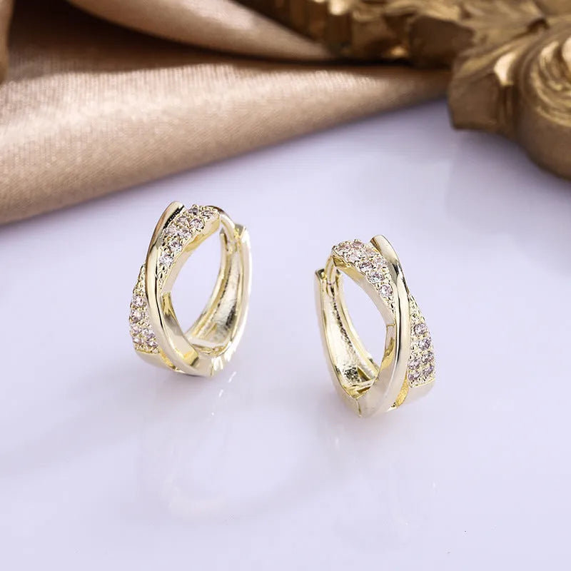A pair of geometric drop earrings in 14K yellow, made from copper with zircon accents.