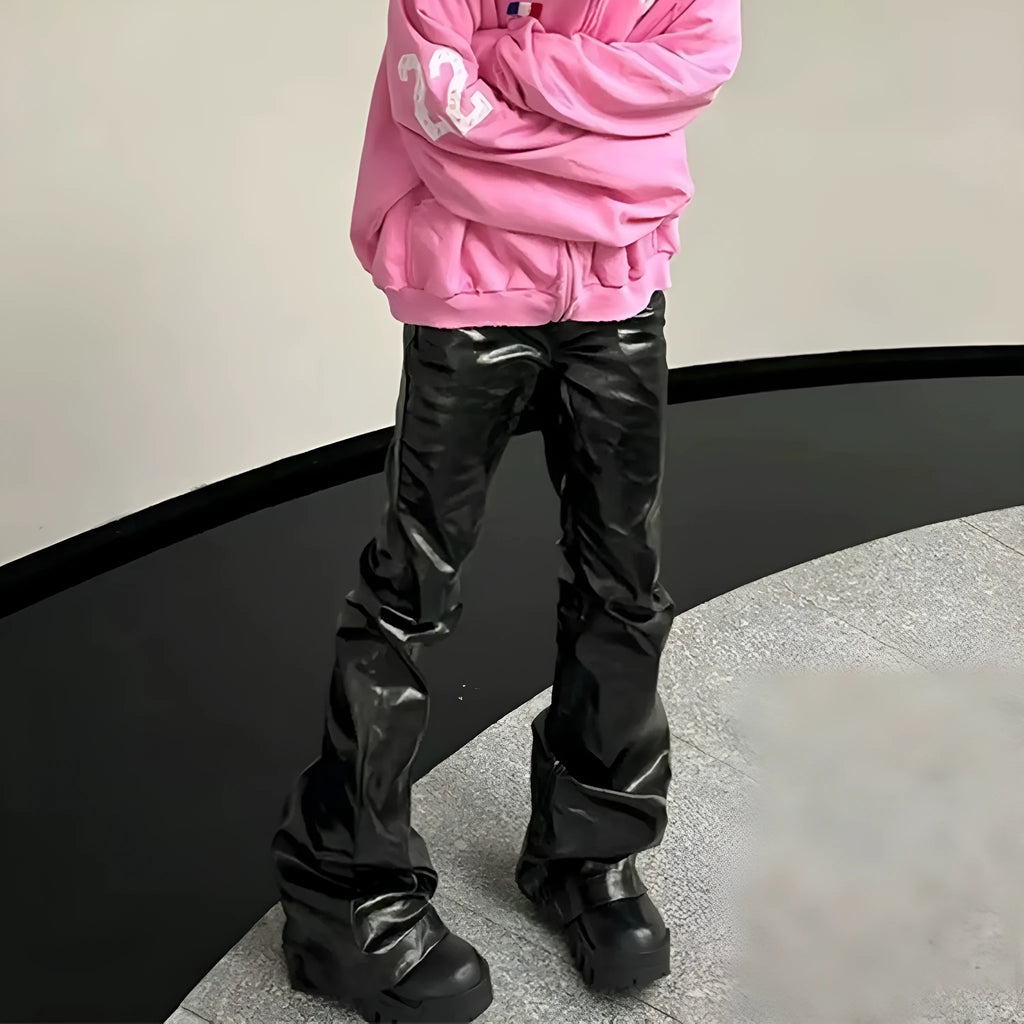 Black skinny jeans with a shiny patent leather coating and straight-leg cut on a denim background.