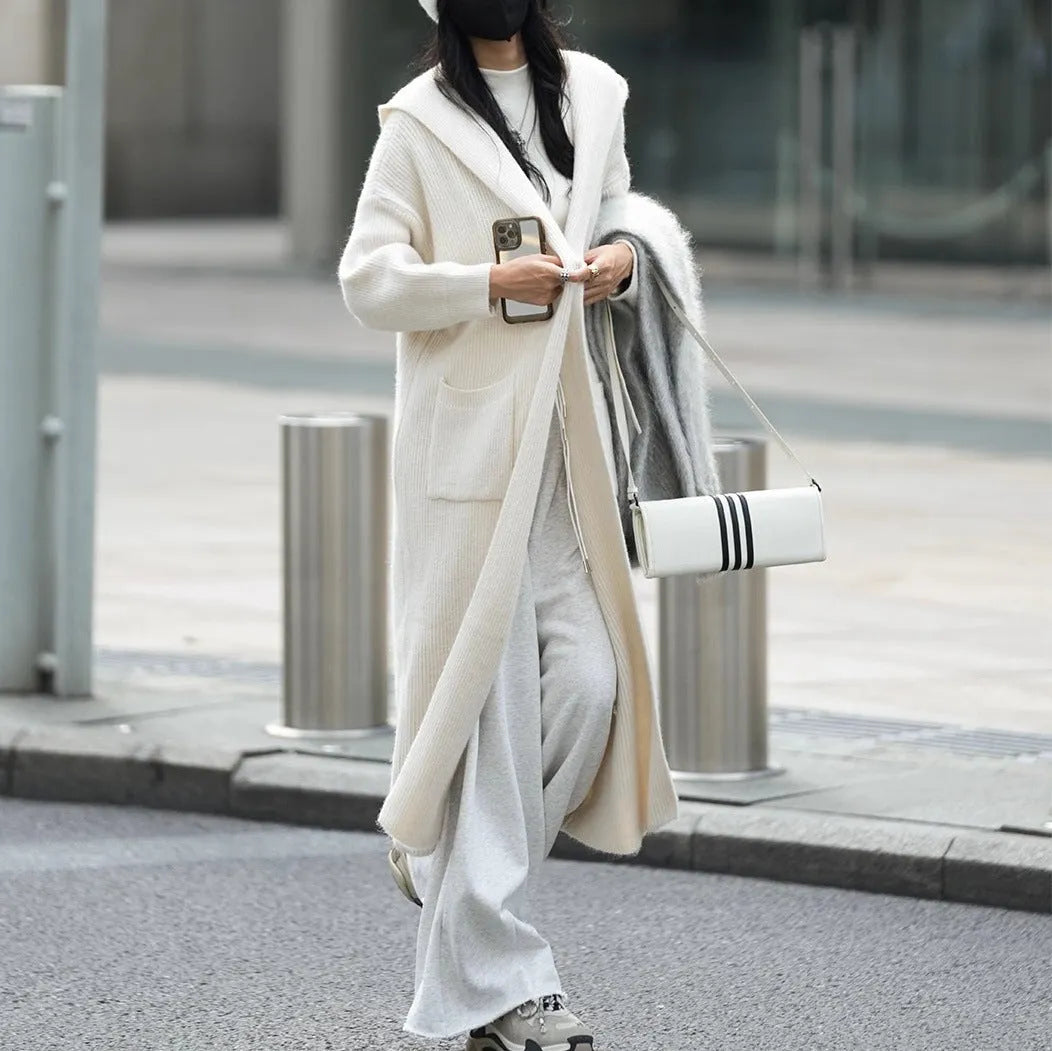 Women's long grey knitted cardigan hooded trench coat on a hanger.