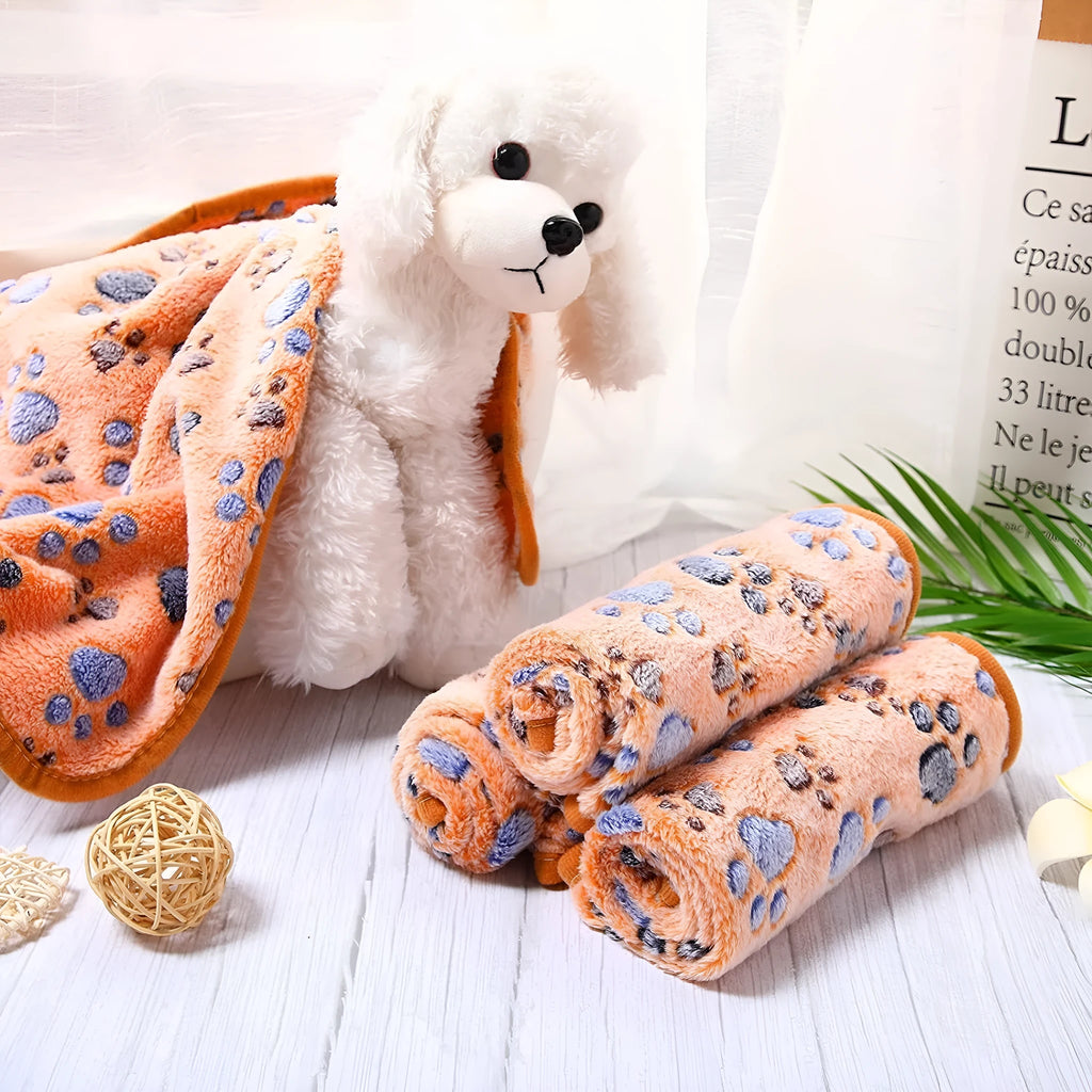 Soft coral fleece dog blanket with a paw print design, shown in a beige colour.