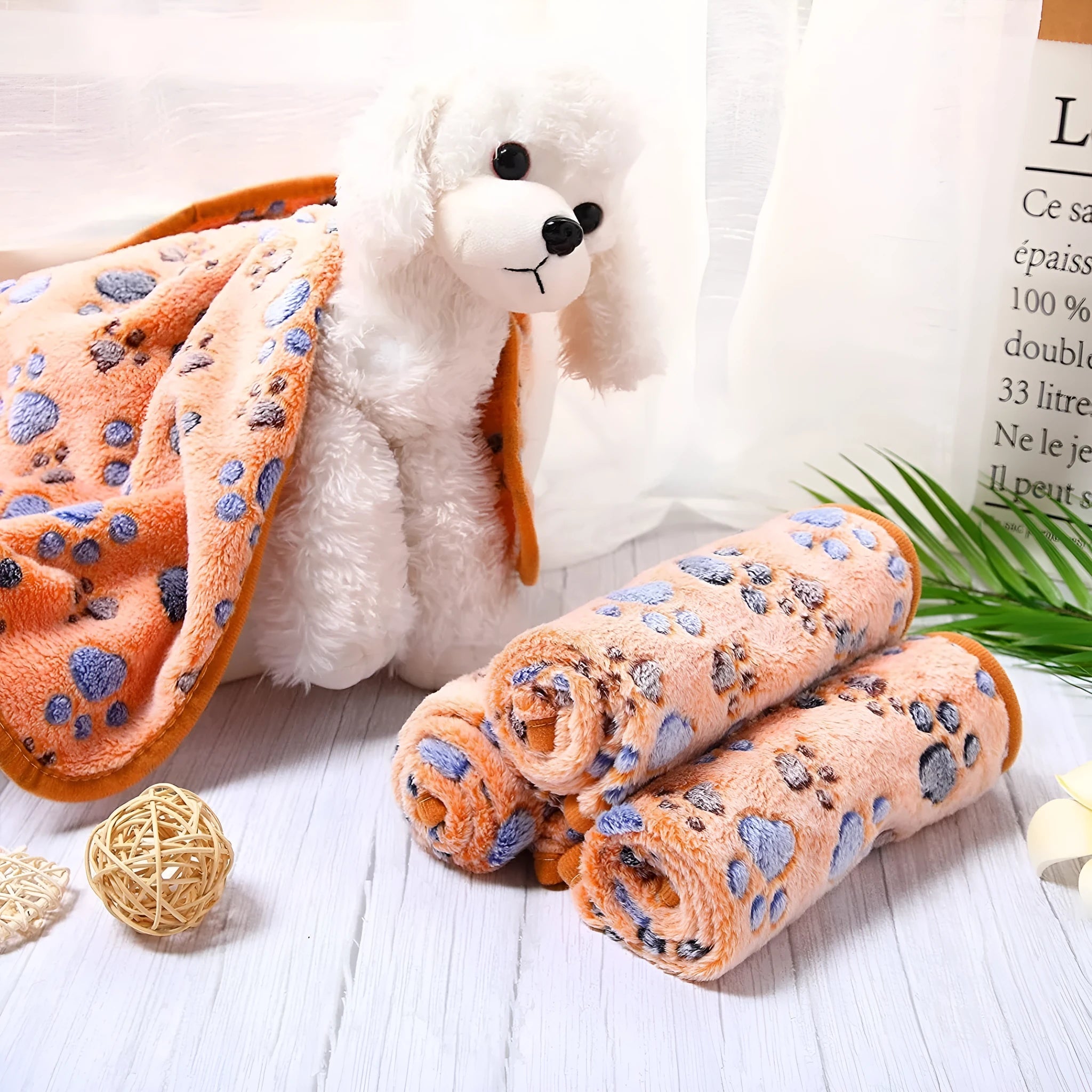 Soft coral fleece dog blanket with a paw print design, shown in a beige colour.