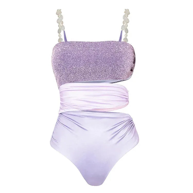 Purple one-piece swimsuit and matching wrap skirt set laid flat.