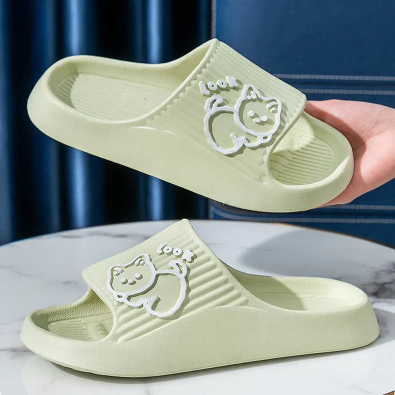 Green cat design thick EVA platform slippers on a wooden floor
