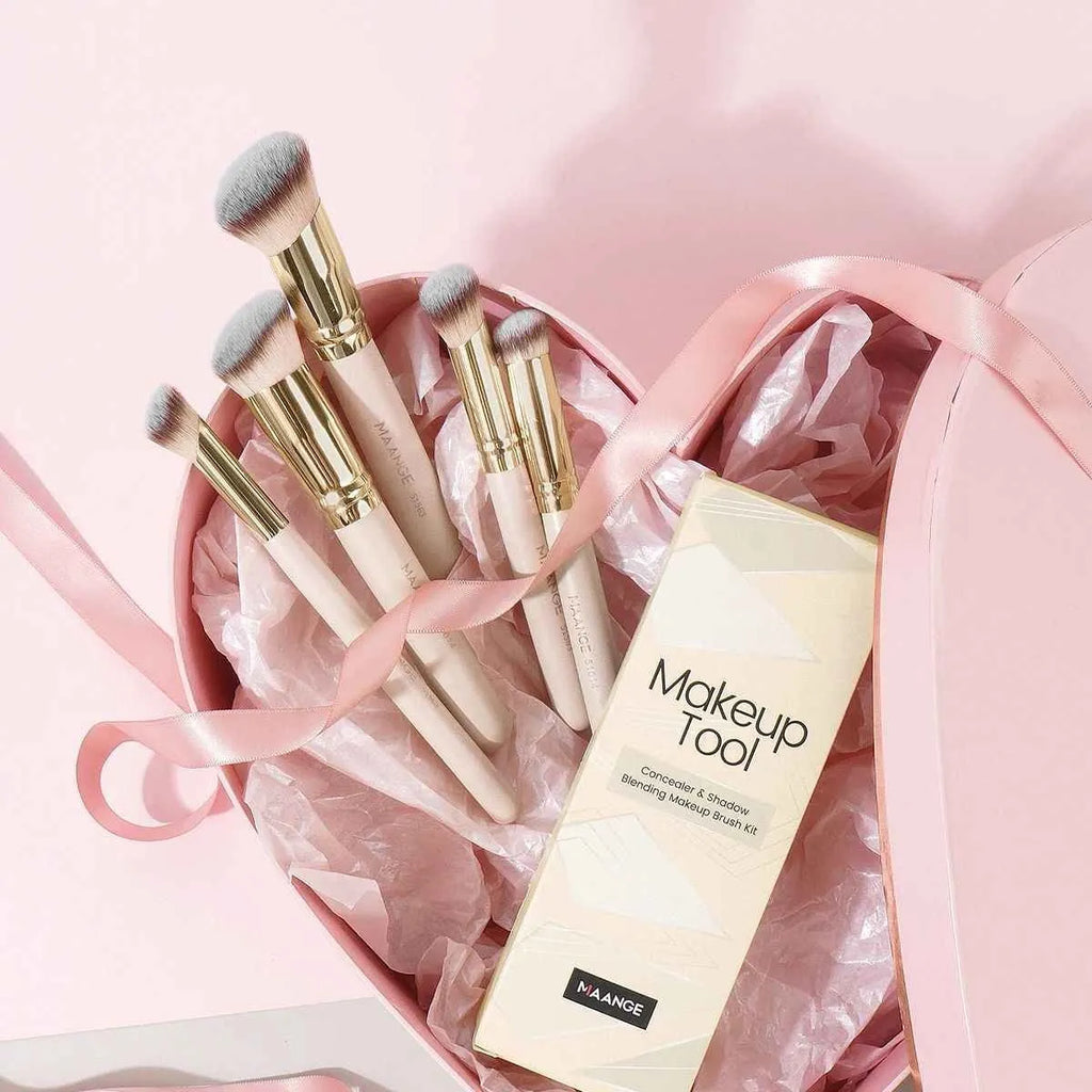 Apricot coloured angled makeup blush brush and four other synthetic brushes from a 5-piece set.