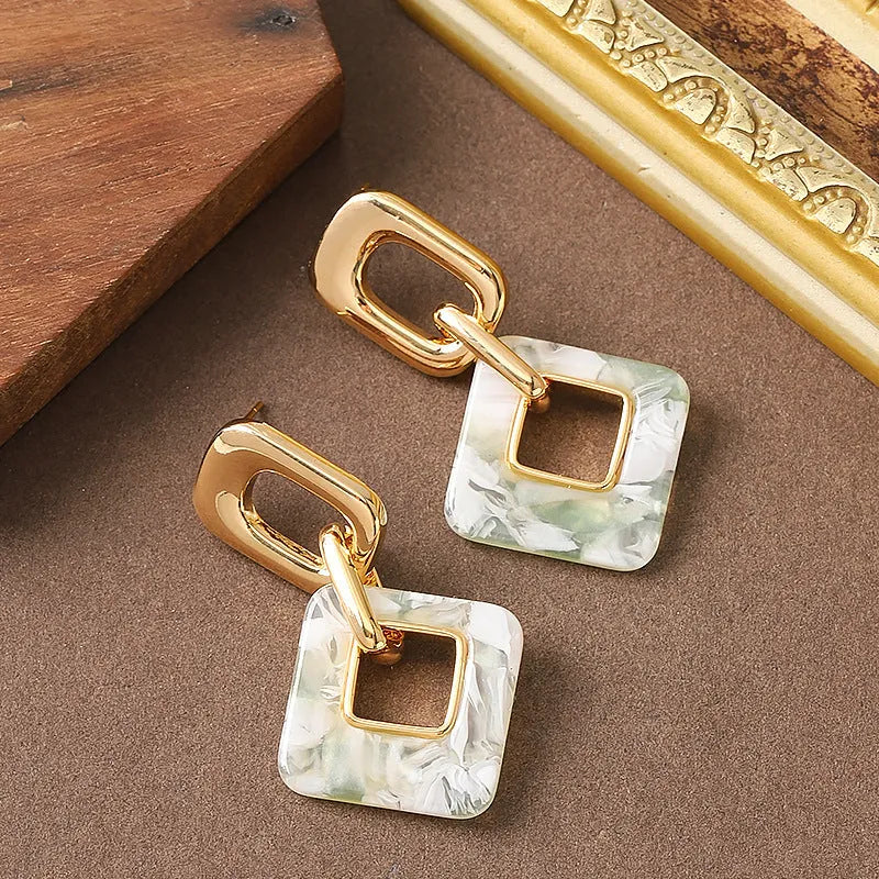 Hollow geometric square earrings with chamfered corners in metallic finish