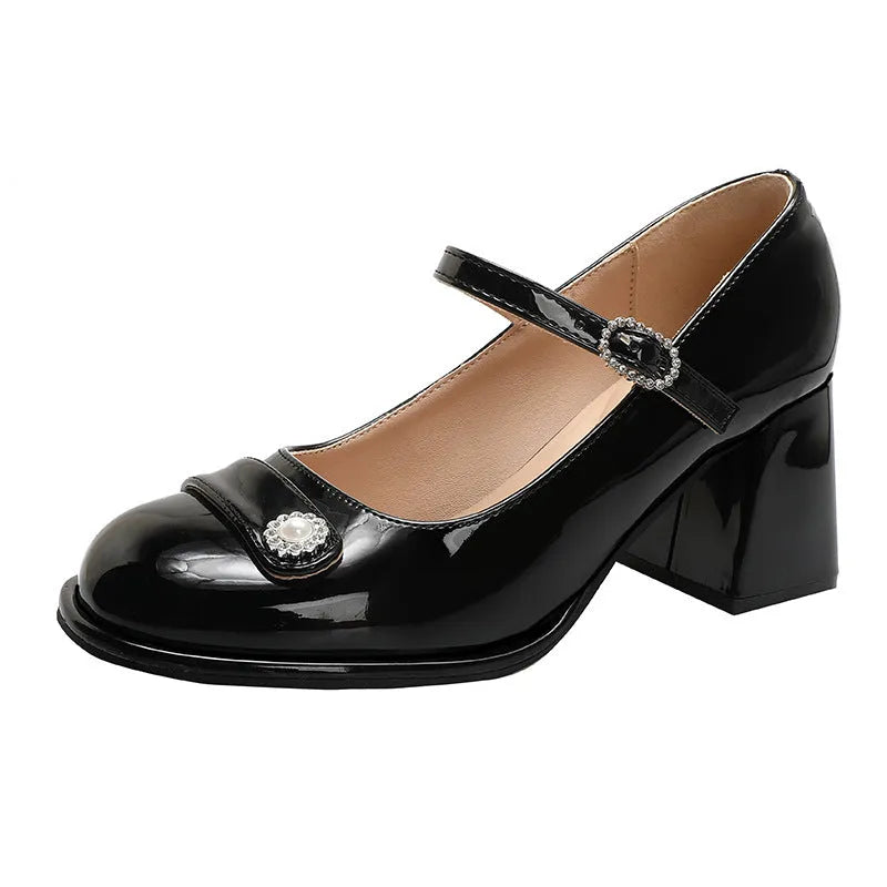 Women's black patent leather round toe shoes with a chunky heel and buckle fastening, shown in a widened fit style.