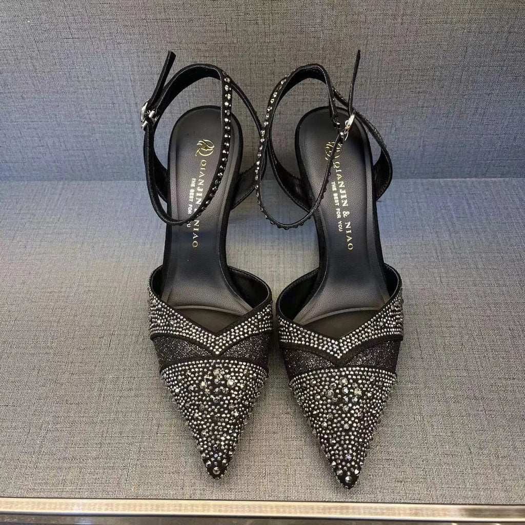 Women's silver high heel shoe with hollow stiletto heel, pointed toe, and bright red sole.