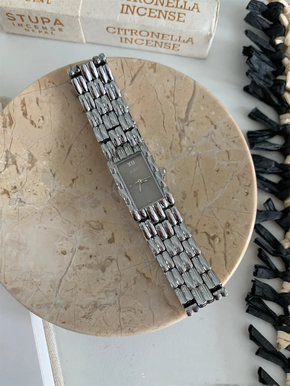 Women's vintage bracelet watch with a small dial, butterfly buckle, on a silver strap.
