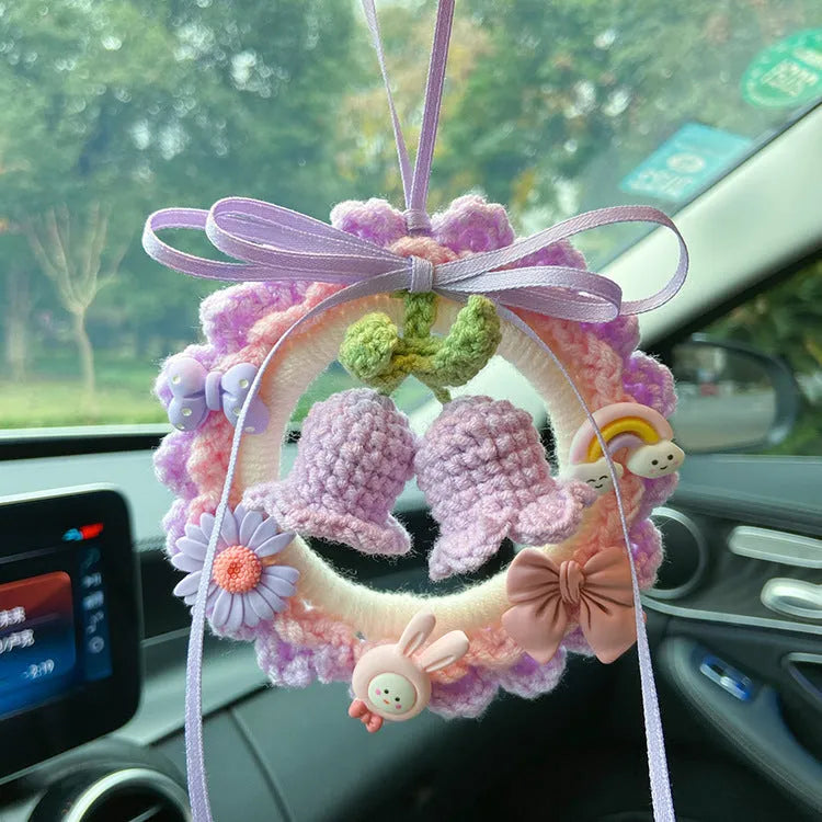 Handwoven wool bell orchid car pendant in green, hanging with dreamcatcher charm.
