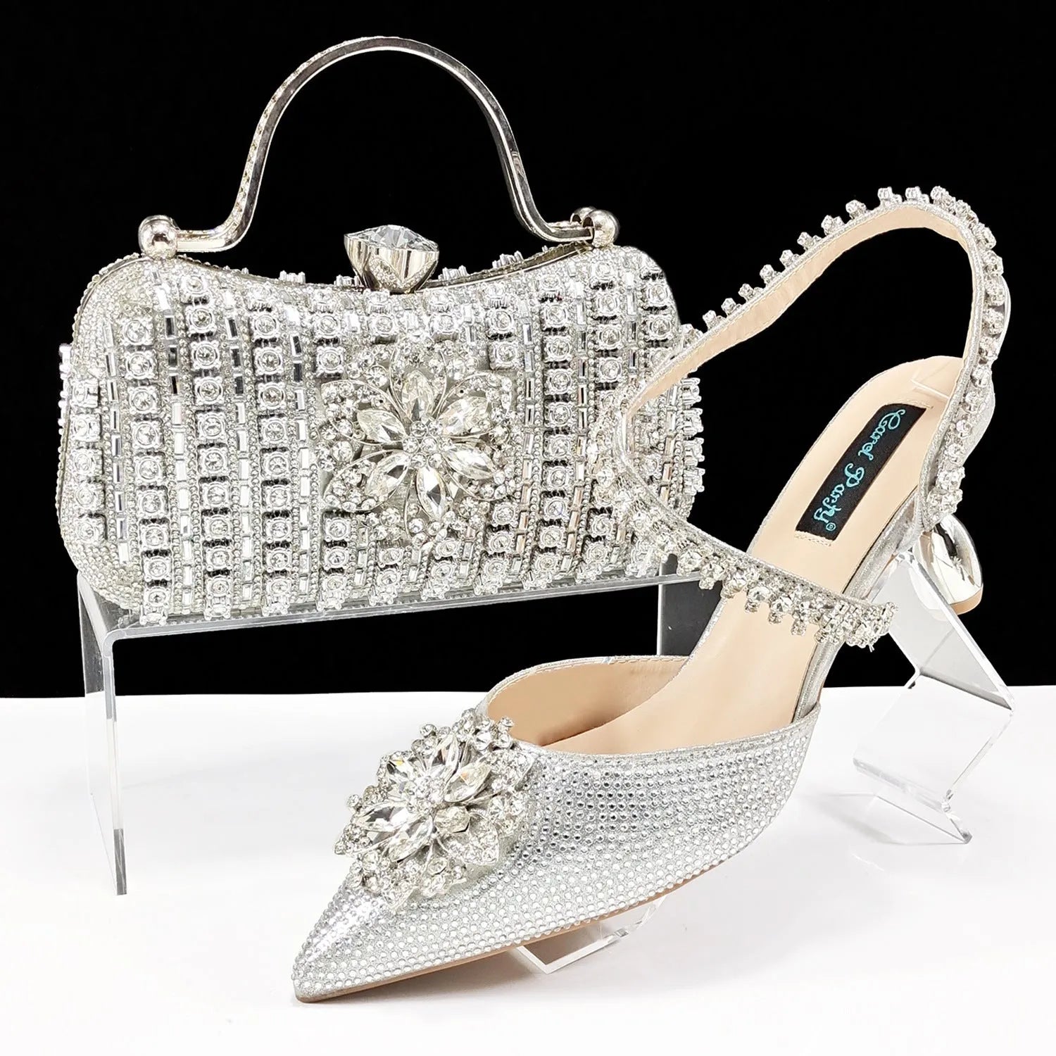 Women's black synthetic leather high-heel shoes with rhinestone ankle chain and matching hard clutch bag.