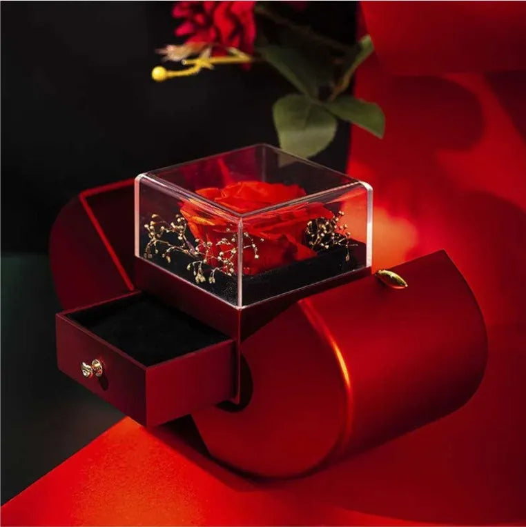 Red apple-shaped jewelry box with eternal soap flower rose and silver necklace inside