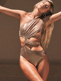 Gold coloured women's backless one-piece swimsuit on a neutral background.