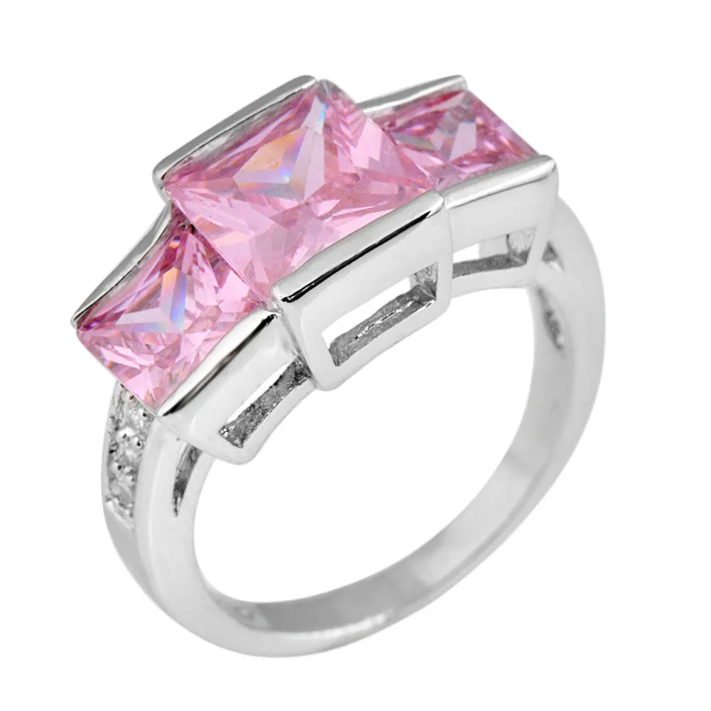 Geometric copper ring for women in champagne colour on a grey background, showing size 8.