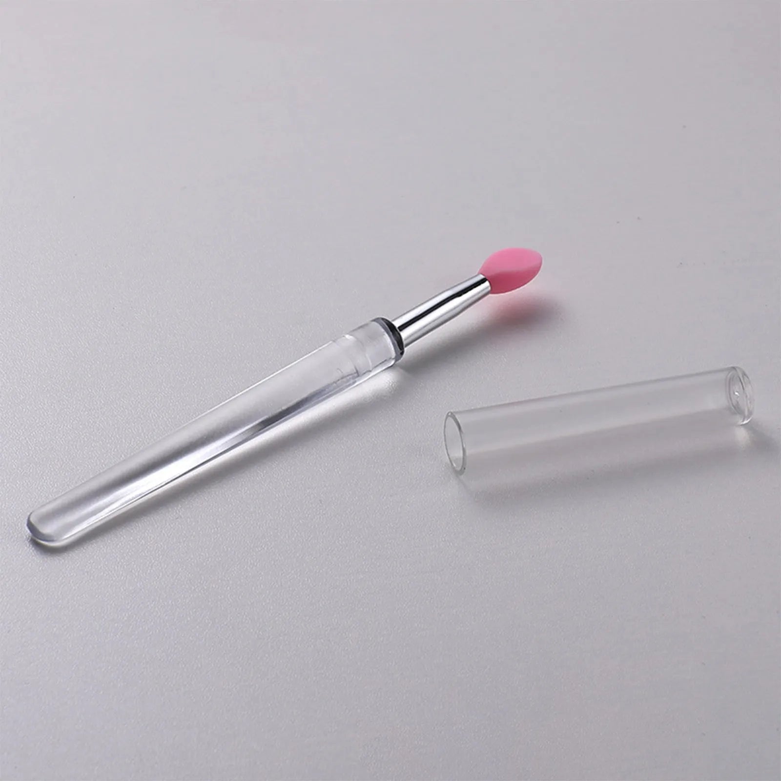 Set of reusable silicone lip brushes with protective caps in various colours.