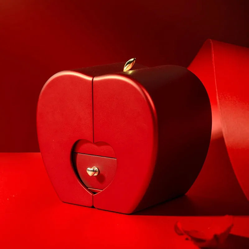 Red apple-shaped jewelry box with eternal soap flower rose and silver necklace inside
