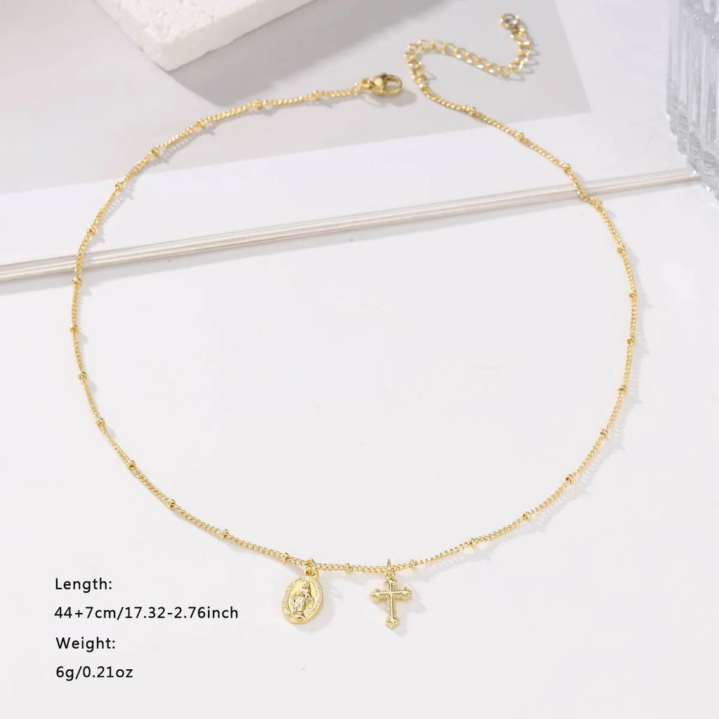 Gold Virgin Mary cross necklace with simple geometric pendant on a chain.
