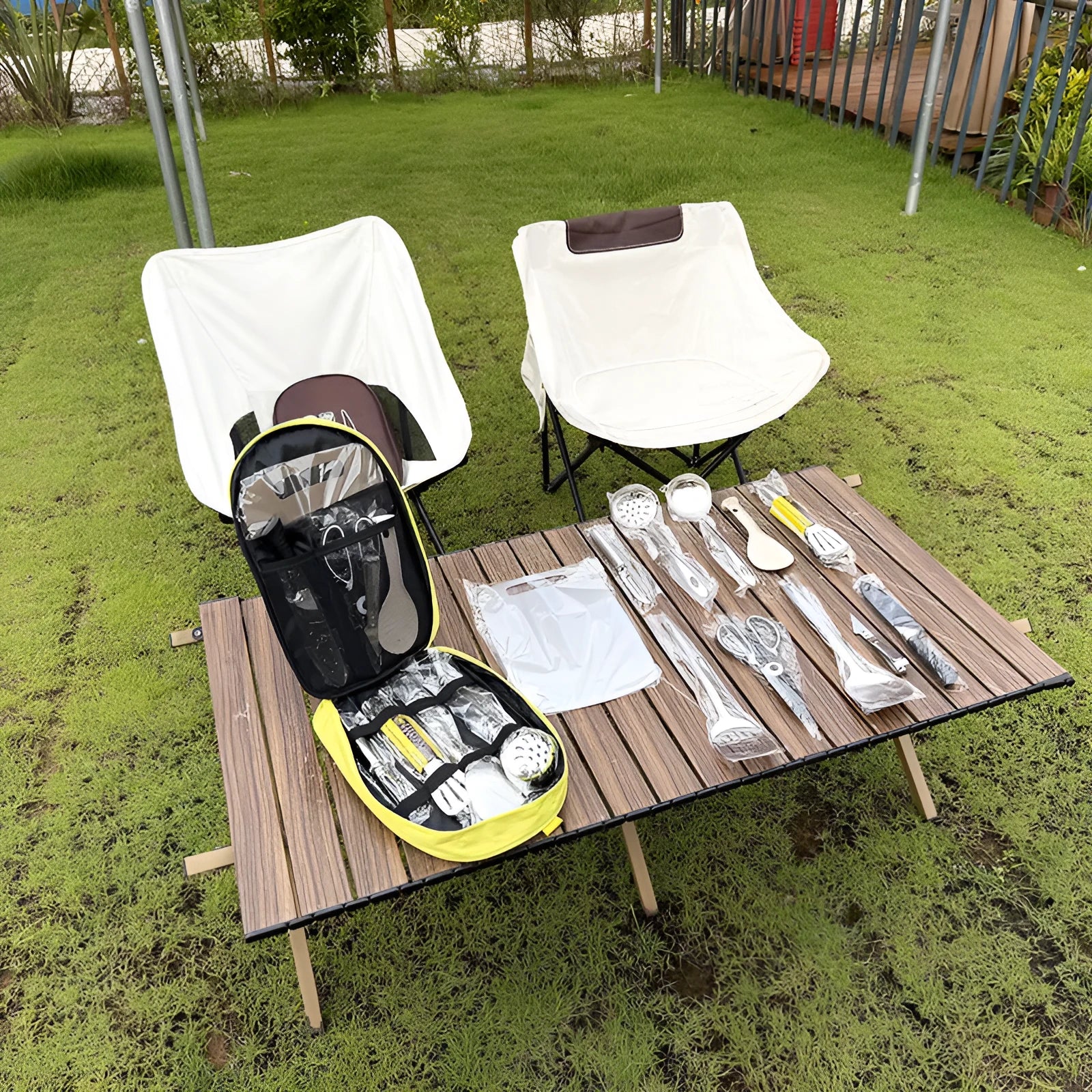 12-piece stainless steel picnic utensil set inside a khaki portable storage bag for outdoor dining.