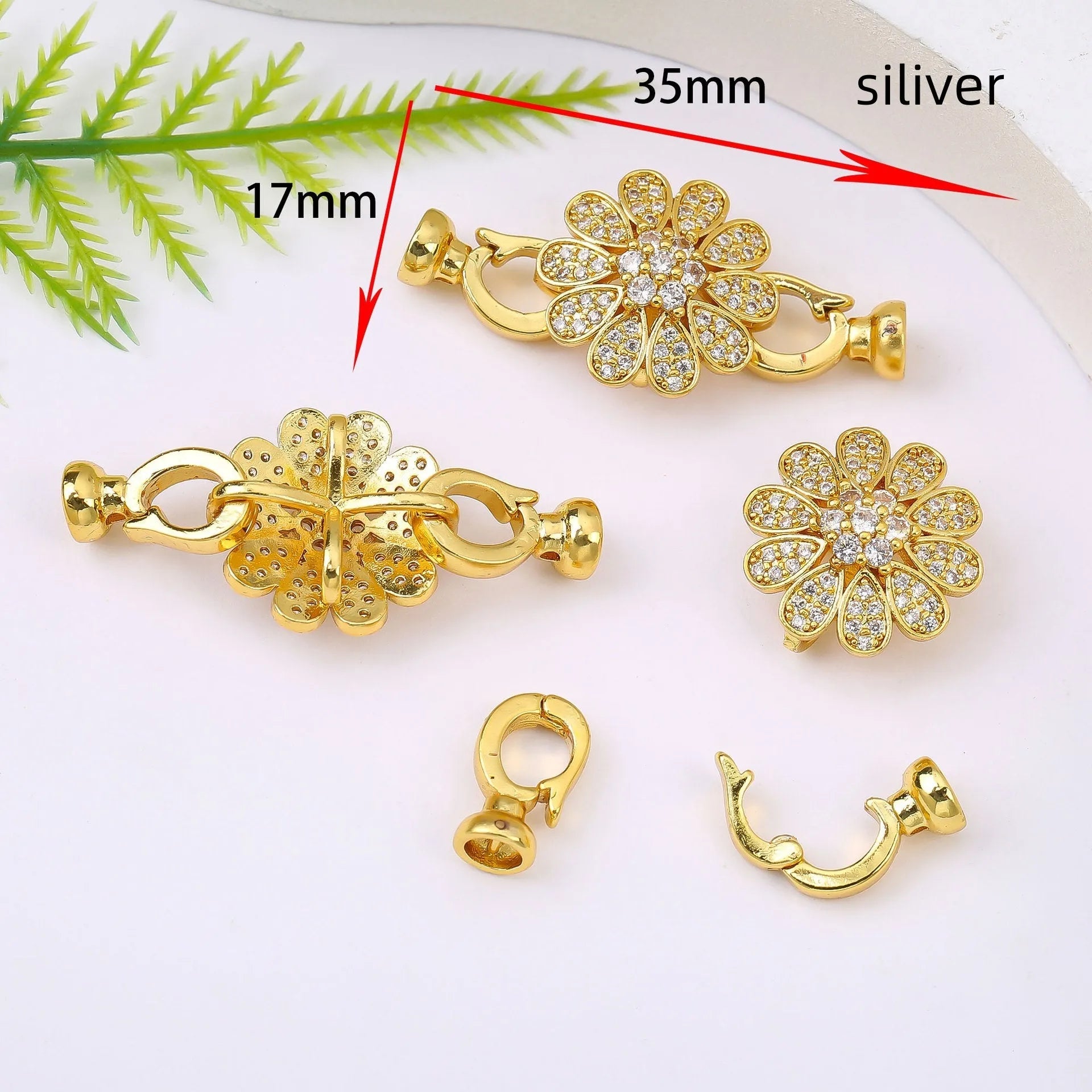 Small gold colour necklace clasp buckle for DIY jewellery on a white background.