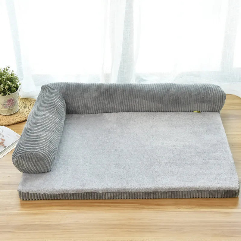 Grey corduroy dog sofa bed with raised sides on a wooden floor, showing its non-slip base.