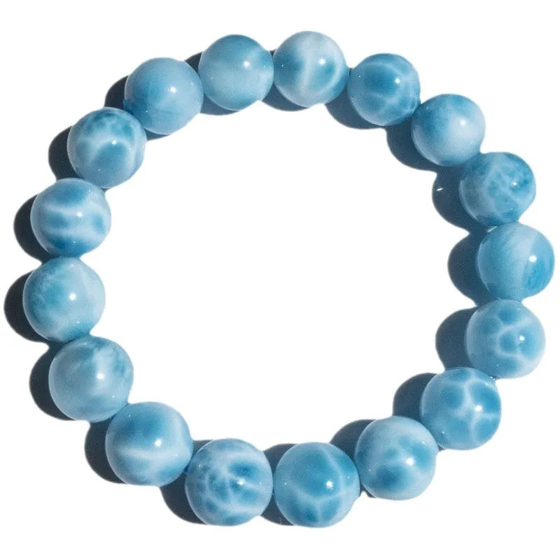 Blue handmade bodhi and pearl bracelet in Maillard style on a neutral background.