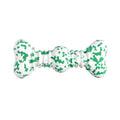 Green and white camouflage patterned natural rubber bone chew toy for dogs on a wooden floor.