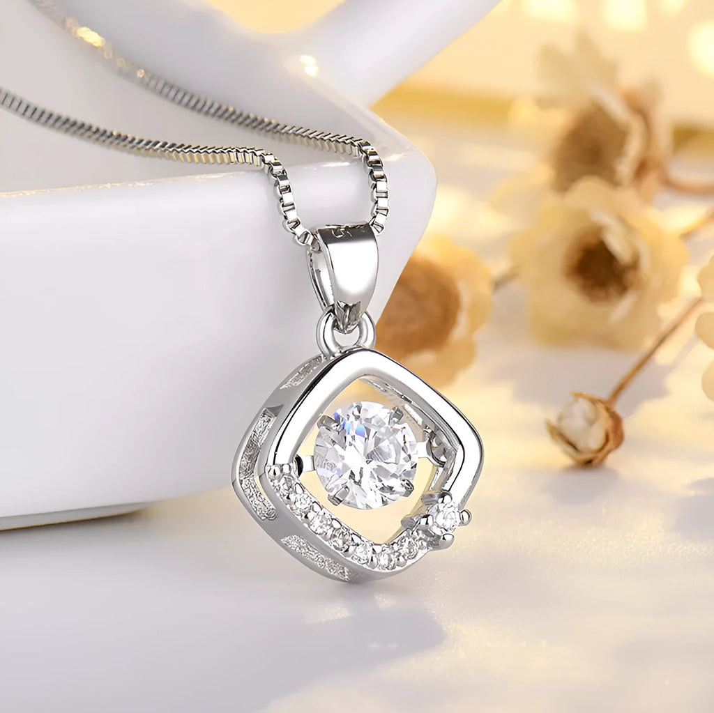 Silver love heart-shaped necklace with crown and bow decoration on clavicle