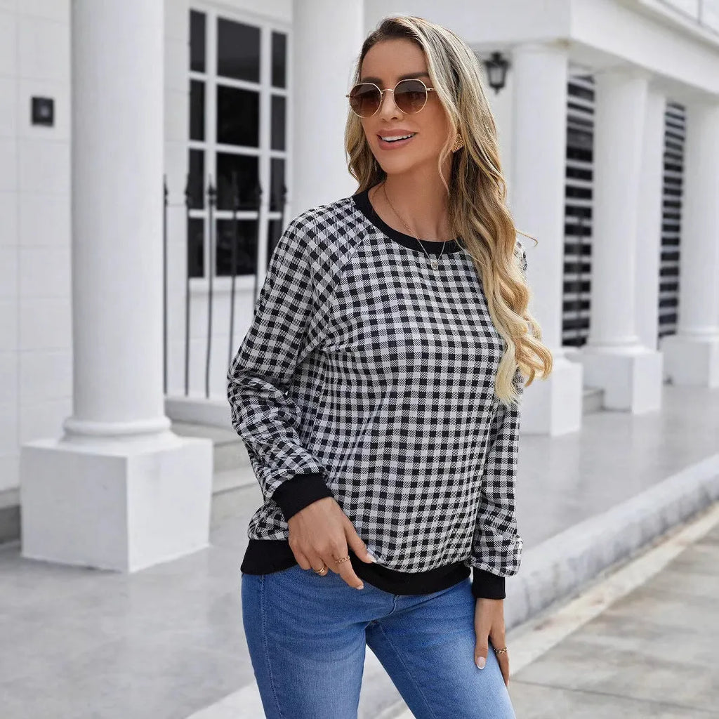Black long sleeve pullover sweater with a striped plaid pattern and printed design detail.
